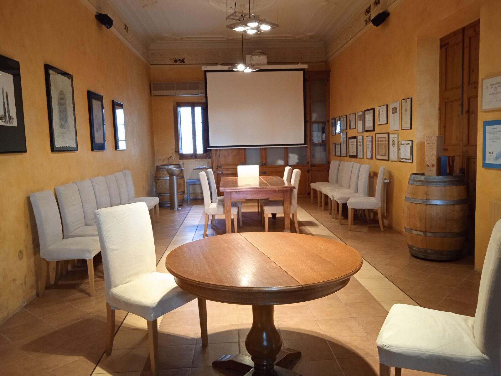 Sala Xarel·lo de Albet i Noya, con proyector, barricas y mesas de madera