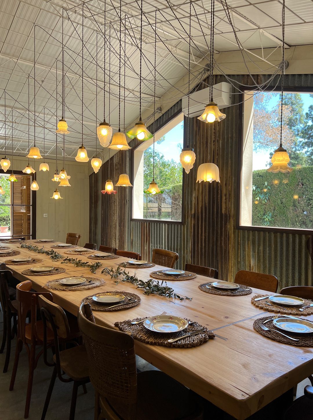 Mesa larga de madera bajo lámparas de cristal en el comedor de Bellesguart
