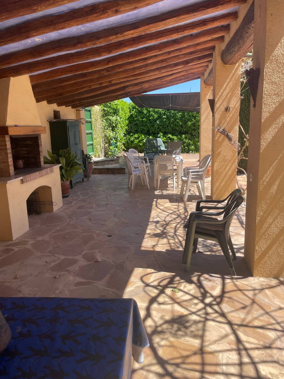 A brick barbecue under the porch’s wooden beams