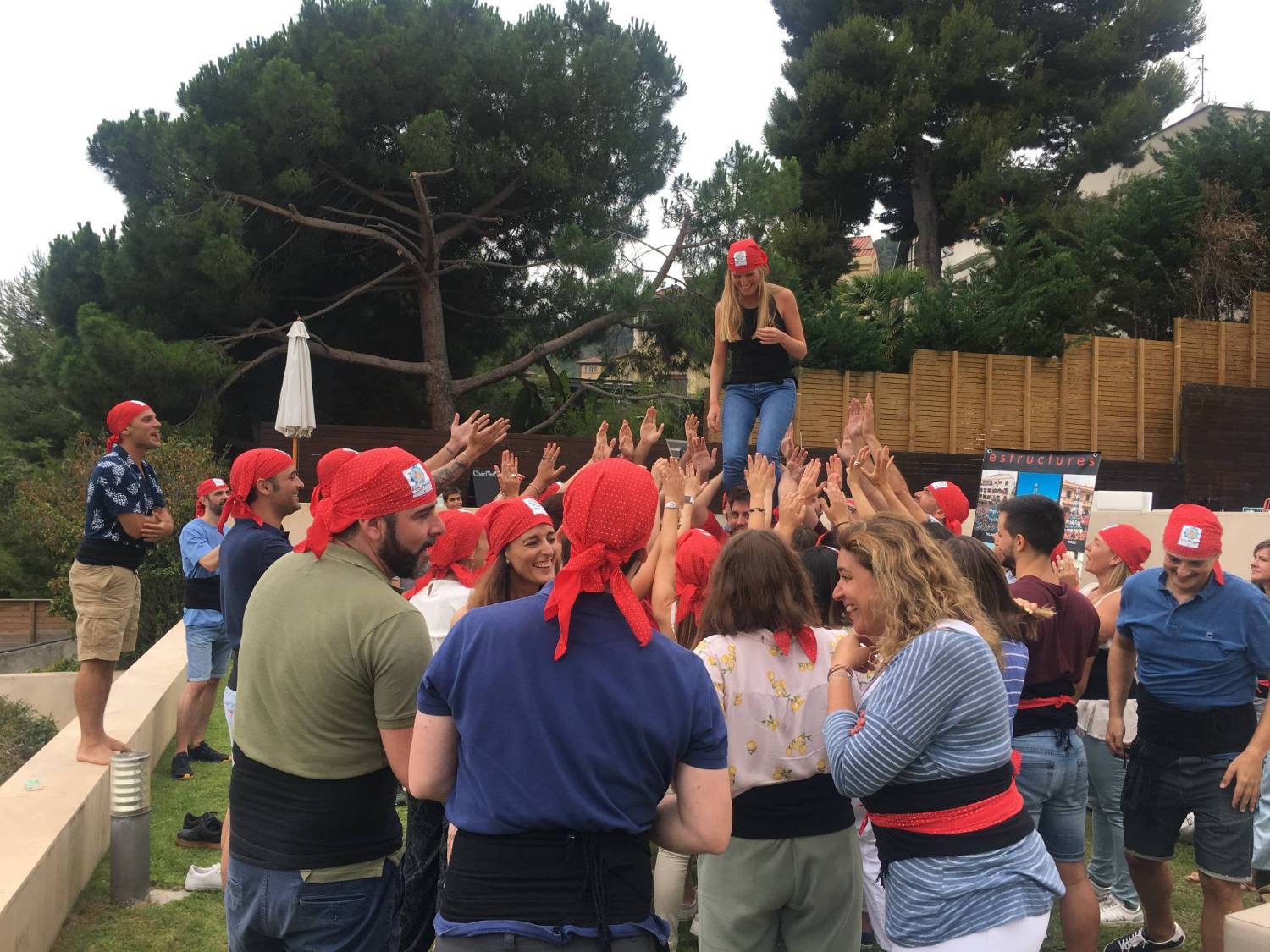 Participants in red headscarves celebrating the completed tower