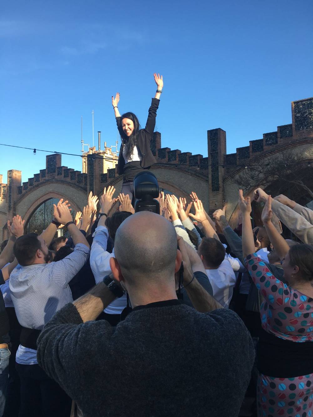 A participant at the very top, with the group applauding from below